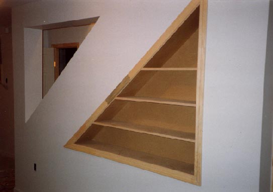 Built-in bookcase under stairs in finished basement
